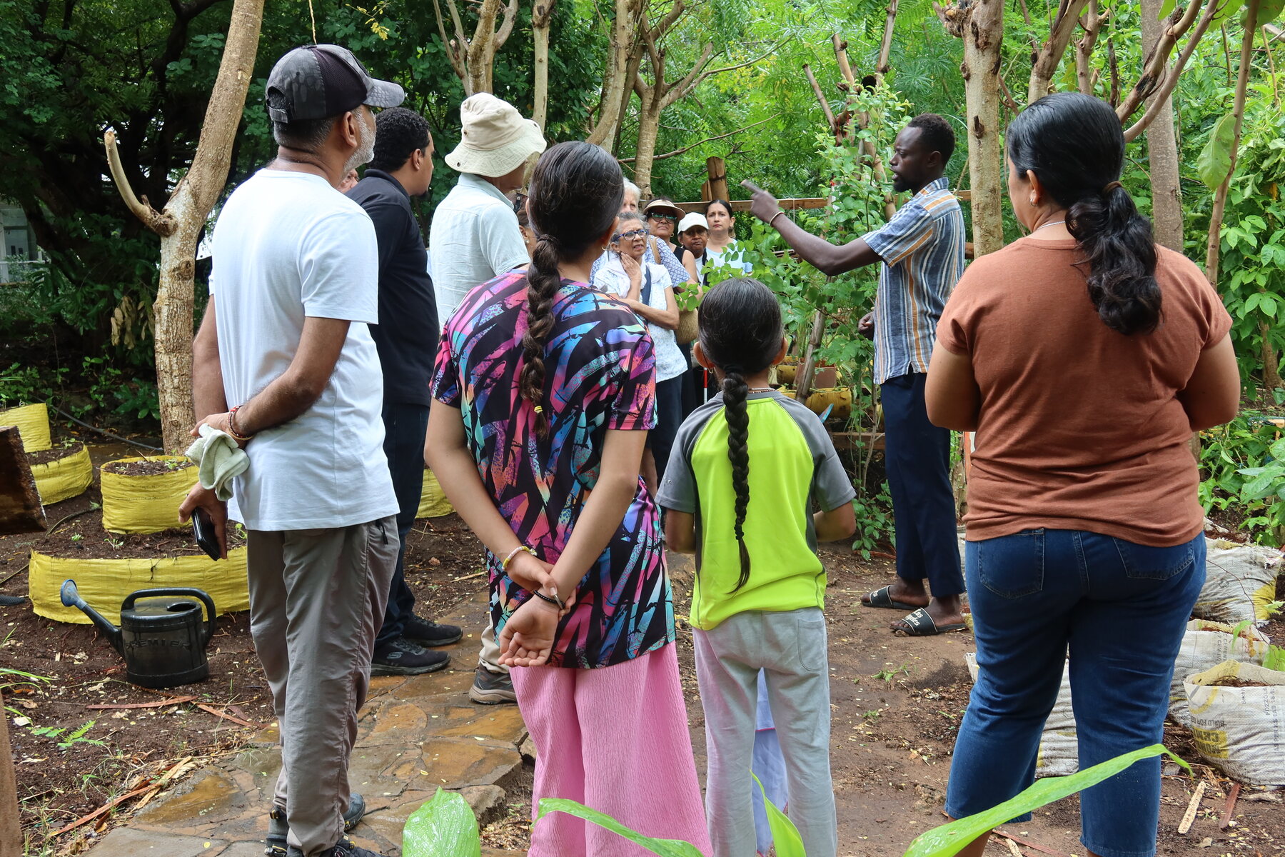 Community members observing a practical garden demonstration.